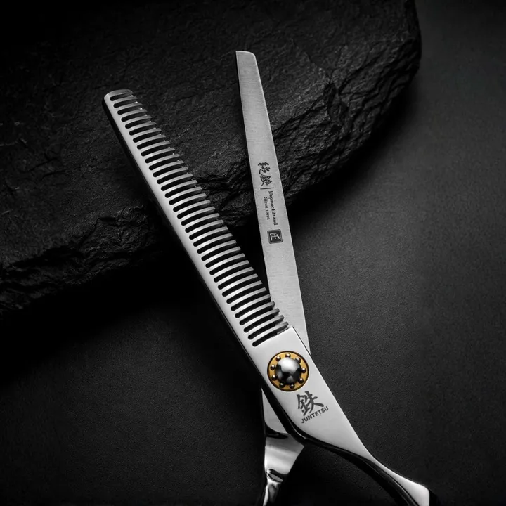 Close-up of Juntetsu Kenshi texturising scissor teeth and gold pivot on black slate
